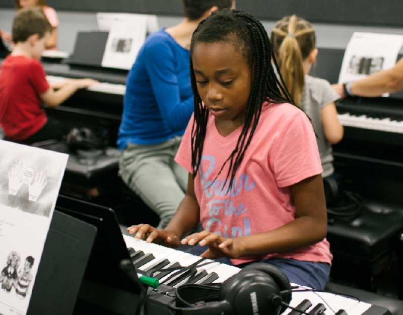 A young girl plays an electronic keyboard in Omaha Conservatory of Music's keyboard lab.