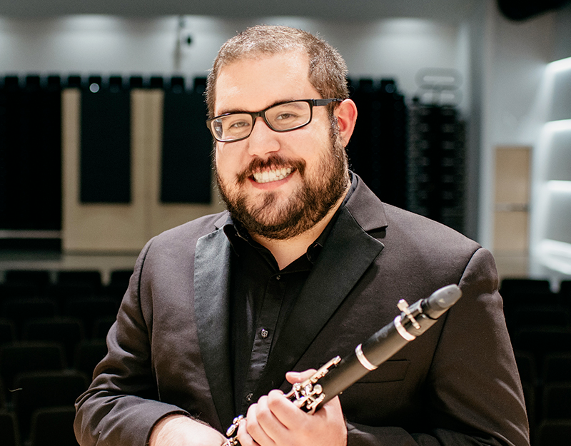 Joe Weber, clarinet Artist-Faculty member at the Omaha Conservatory of music, smiles for a portrait while holding a clarinet