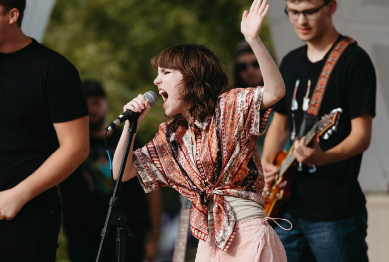 Photo of a Rock Lab student singing during a performance at the Battle of the Bands at Gene Leahy mall.